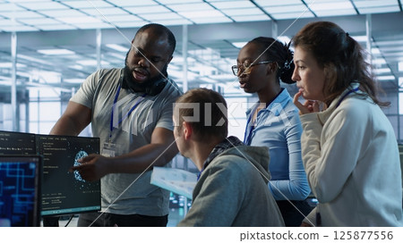 Technician doing brainstorming with colleagues to fix error in code affecting server room AI workloads. Team of artificial intelligence engineers repairing data center systems together, camera A 125877556