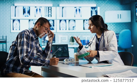 Indian medic giving a box of supplements and antibiotics at check up, offering support and prescription drugs for wellness. Male specialist recommends tablets with the right dosage. Camera B. 125877557