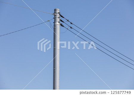 Electric poles and wires drawing line drawings in the blue sky Electric poles and wires drawing line drawings in the blue sky 125877749