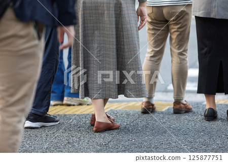 Back view of people waiting for the traffic light at an intersection 125877751