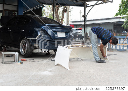 Checking car body work fiber bumper at car garage Checking car body work fiber bumper at car garage 125877897