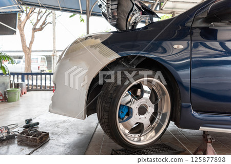 Checking car body work fiber bumper at car garage 125877898