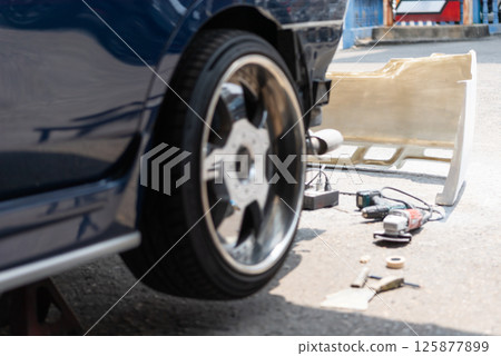 Checking car body work fiber bumper at car garage 125877899