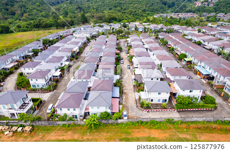New development real estate. Aerial view of residential houses and driveways neighborhood during a fall sunset or sunrise time. Tightly packed homes. Top view over private houses in phuket thailand 125877976