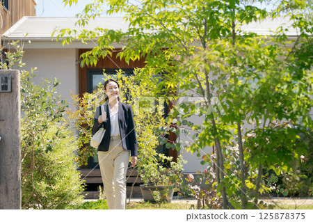 A woman in a suit leaving the entrance A woman in a suit leaving the entrance 125878375
