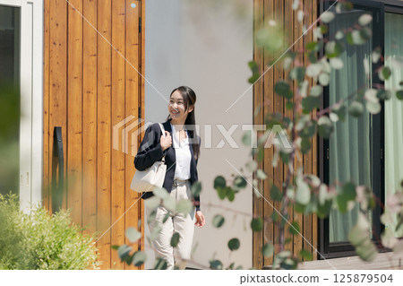 一名身著西裝的女子走出入口 一名身著西裝的女子走出入口 125879504