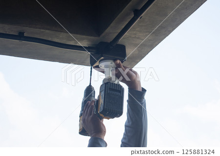 Technician installing CCTV camera system for security area Technician installing CCTV camera system for security area 125881324