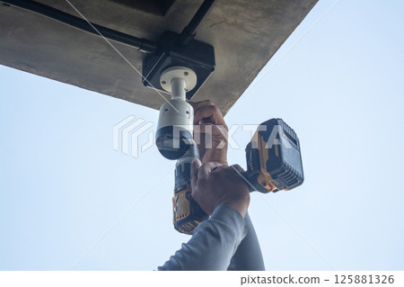 Technician installing CCTV camera system for security area Technician installing CCTV camera system for security area 125881326