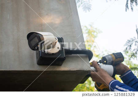 Technician installing CCTV camera system for security area Technician installing CCTV camera system for security area 125881329