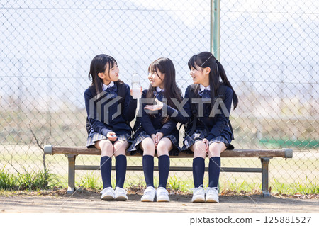 Female student sitting on a bench on the grounds 125881527