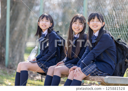 Female student sitting on a bench on the grounds Female student sitting on a bench on the grounds 125881528
