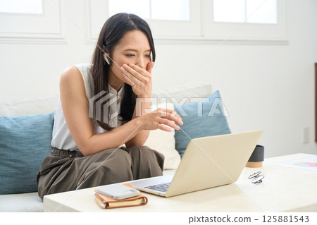 Woman looking at computer screen seriously Trouble Surprising Sad News 125881543