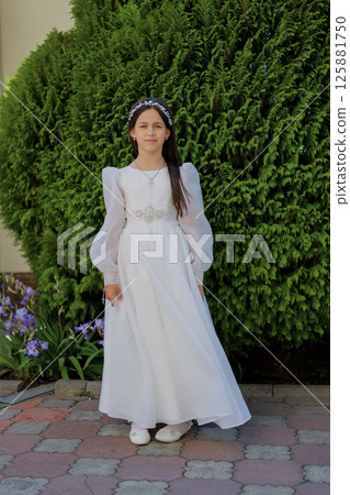 A little lady in a white dress prepares for the sacrament with quiet emotion. A sweet girl in a long white gown. 125881750