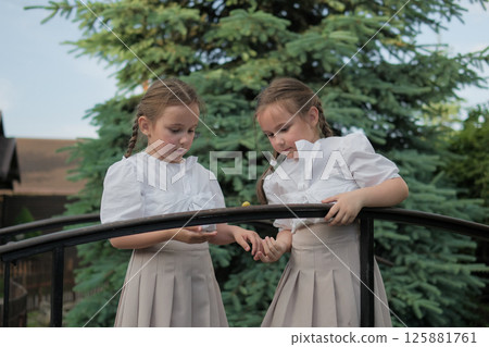 Two children form a harmonious composition around the snail. Light fabrics contrast nicely with the dark wood. Two children form a harmonious composition around the snail. Light fabrics contrast nicely with the dark wood. 125881761