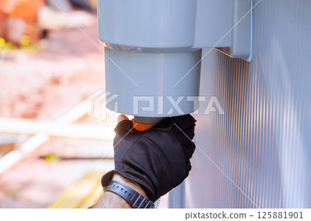 Worker attaching component to filter tank system construction at assembly swimming pool for pool maintenance 125881901