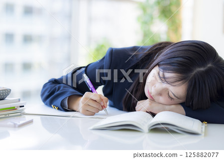 High school girl taking a nap at the desk High school girl taking a nap at the desk 125882077