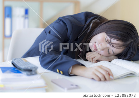 High school girl taking a nap at the desk 125882078