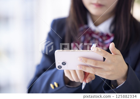 女高中生用智慧型手機學習的手 125882334