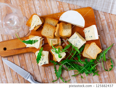 Blue cheese served with toast and arugula Blue cheese served with toast and arugula 125882437
