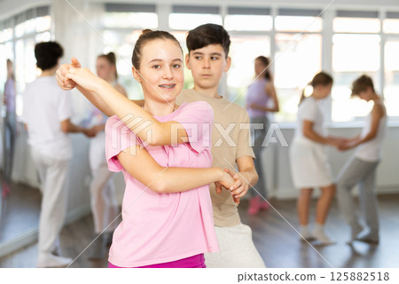 Girl dances Latin dance with male boy teen partner during choreography lesson 125882518
