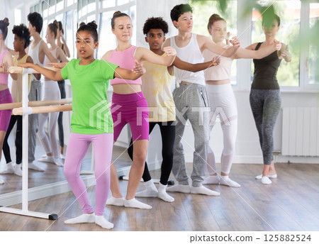 Teenage girl practicing plie position of ballet during choreography classes 125882524