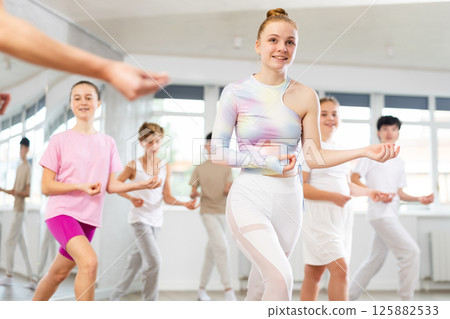 Girl teen teaches energetic mobile social house dance together with friends 125882533