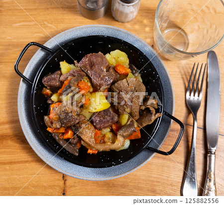There is portion of hearty lunch on table - veal with stewed vegetables and mushrooms There is portion of hearty lunch on table - veal with stewed vegetables and mushrooms 125882556