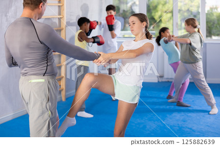 Coach and girl training self-defense techniques 125882639