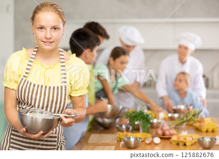 Teenage girl learns to cook at master class Teenage girl learns to cook at master class 125882676