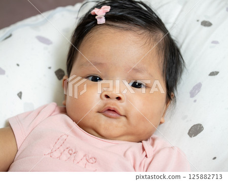 Newborn baby portrait asian infant home setting close-up gentle expression for seo impact 125882713