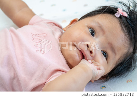 Newborn asian baby smiling in cozy nursery candid moment indoor peaceful setting Newborn asian baby smiling in cozy nursery candid moment indoor peaceful setting 125882718