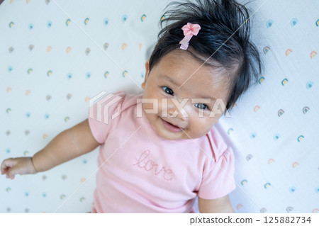 Joyful newborn baby smiling asian infant in cozy room child bright atmosphere heartwarming concept Joyful newborn baby smiling asian infant in cozy room child bright atmosphere heartwarming concept 125882734