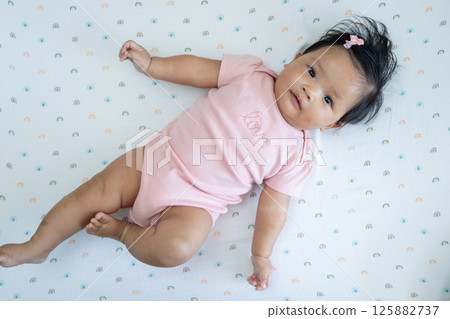 Newborn asian baby's charming moment cozy nursery portrait bright setting top view concept 125882737