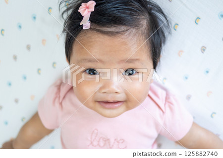 Newborn asian baby smiling soft blanket indoor setting joyful moment captured Newborn asian baby smiling soft blanket indoor setting joyful moment captured 125882740