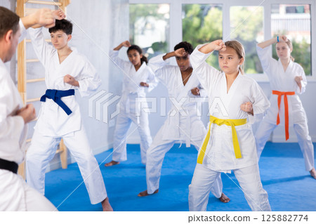 Group of children train karate techniques Group of children train karate techniques 125882774