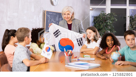 Mature female teacher tells pupils the history of Republic of Korea 125882801