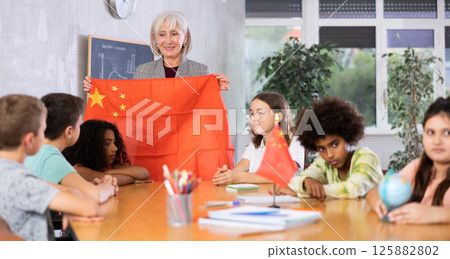 Mature teacher tells pupils the history of China 125882802