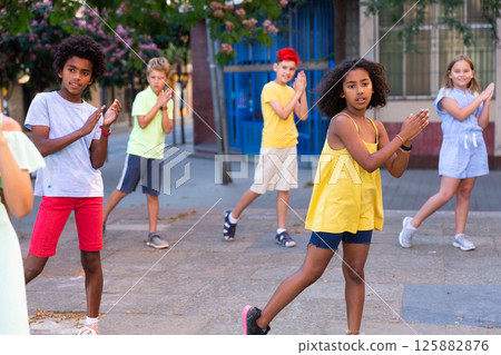 Children exercising contemporary dance moves outdoors Children exercising contemporary dance moves outdoors 125882876