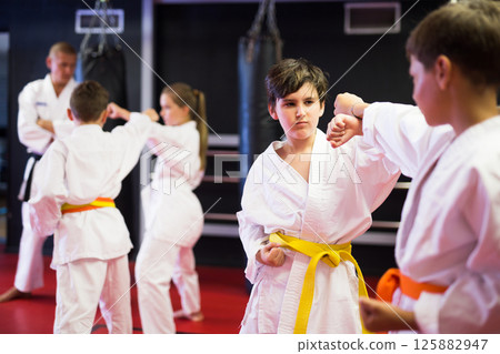 Boys and girls in kimono sparring together Boys and girls in kimono sparring together 125882947
