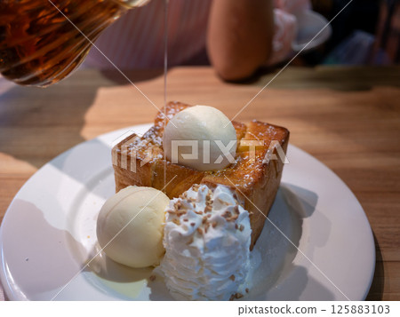 Indulging in honey toast dessert cozy  sweet treat intimate setting close-up view tempting delight 125883103