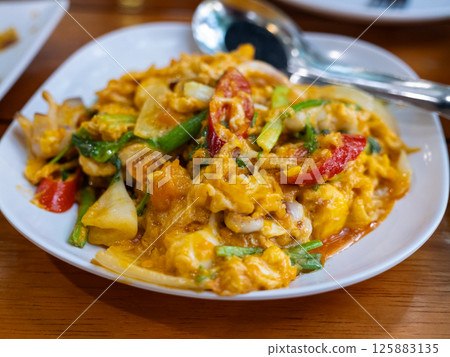 Sizzling stir-fried seafood dish local eatery food cozy ambiance close-up culinary delight 125883135