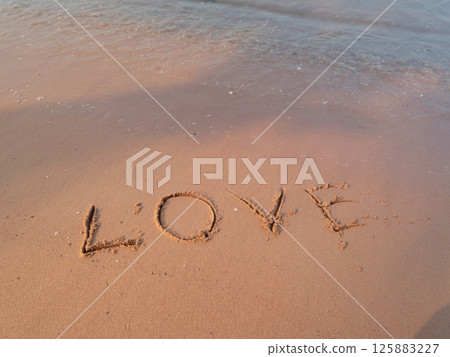 Love etched sand beach setting serene environment close-up view romantic concept Love etched sand beach setting serene environment close-up view romantic concept 125883227