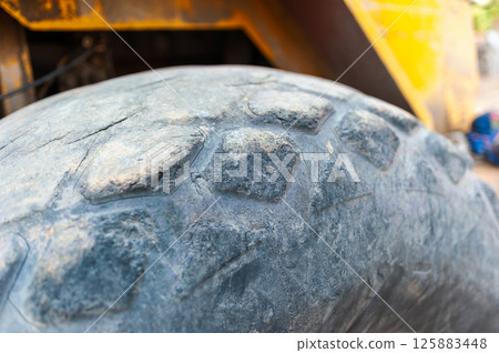 Heavy machinery action close-up of tire tread in industrial site Heavy machinery action close-up of tire tread in industrial site 125883448