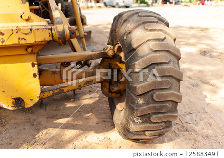 Construction vehicle tire close-up job site machinery outdoor ground level industrial details 125883491