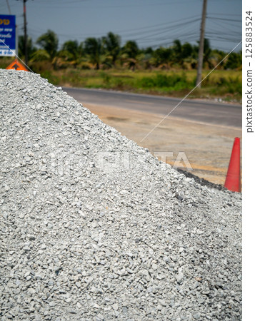 Gravel pile delivery construction materials in urban roadside quarry environment Gravel pile delivery construction materials in urban roadside quarry environment 125883524