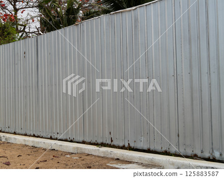 Metal fence surrounding a quiet space urban area outdoor perspective security and privacy Metal fence surrounding a quiet space urban area outdoor perspective security and privacy 125883587