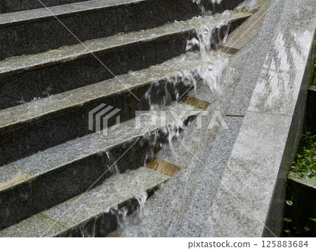 Water flowing down steps urban park nature scene tranquil environment close-up perspective Water flowing down steps urban park nature scene tranquil environment close-up perspective 125883684