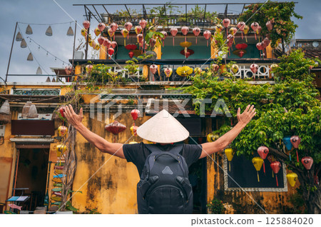 back of an Asian man traveler tourist in traditional vietnamese Non La hat on street in the old town in Hoi An city in Vietnam in Asia back of an Asian man traveler tourist in traditional vietnamese Non La hat on street in the old town in Hoi An city in Vietnam in Asia 125884020