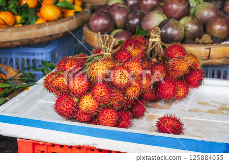 Fresh ripe rambutans on market counter. Sweet exotic tropical fruit 125884055