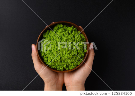 Wolffia or watermeal in bowl with hand on black background 125884100
